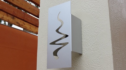 Photo of a custom logo light sconce designed by Electremedia for Pinehurst Apartments in Oklahoma City.