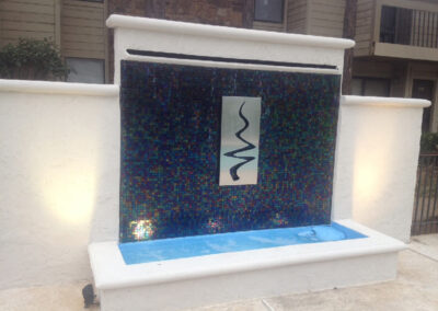 Metal logo for pool area water wall.