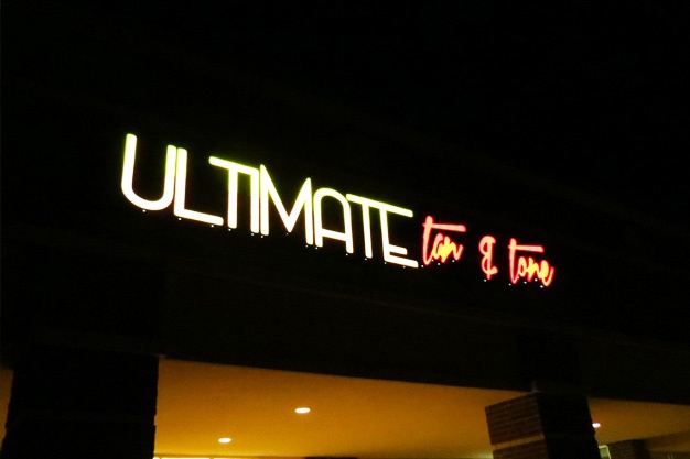 Nighttime picture of tanning salon sign.