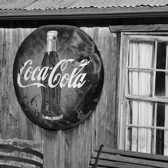 Black and white picture of old architectural coke sign.